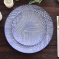 Blue patterned serving plates stacked on a wooden table.