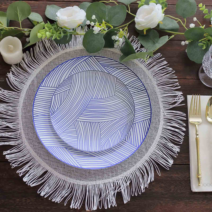 Decorative plates on a fringed placemat with greenery and flowers.