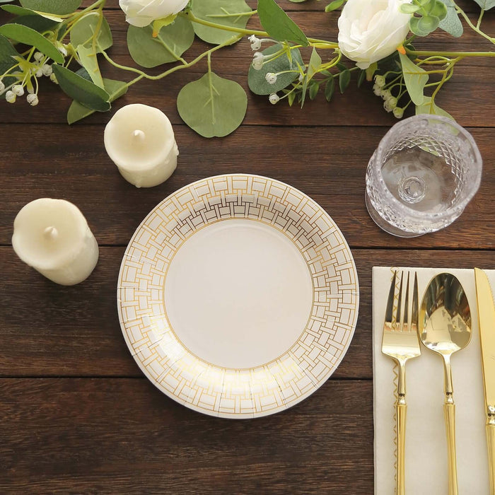 Elegant white plate with gold geometric design, styled with cutlery and candles.
