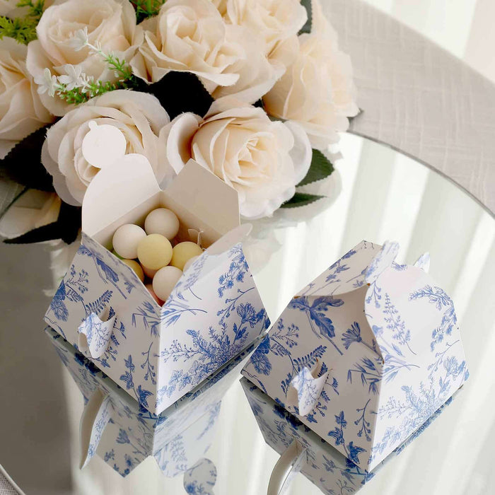 Decorative floral takeout boxes with round candies on a reflective surface.