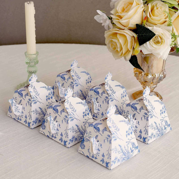Decorative floral gift boxes arranged on a table with a bouquet and candle.