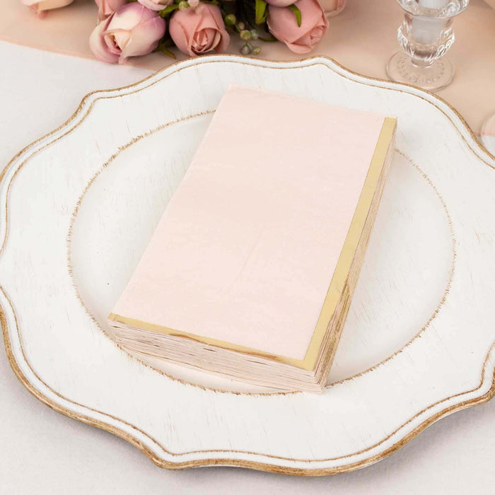 Pink napkin with gold trim on an elegant plate, surrounded by floral decor.