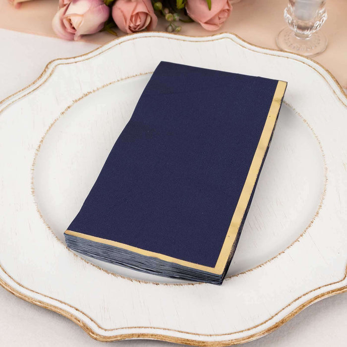 Navy blue napkin with gold trim on a decorative plate