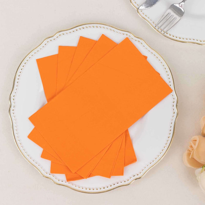 Orange napkins stacked on a decorative plate for elegant table settings.