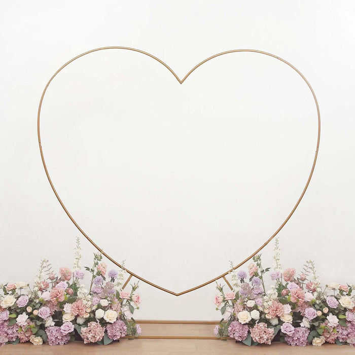 Gold heart-shaped photo backdrop with floral arrangement at the base.