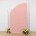 Pink fabric backdrop with floral arrangements at the base.