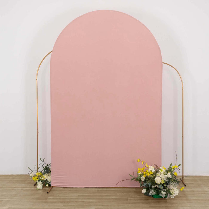 Pink arch backdrop with floral arrangements on the floor.