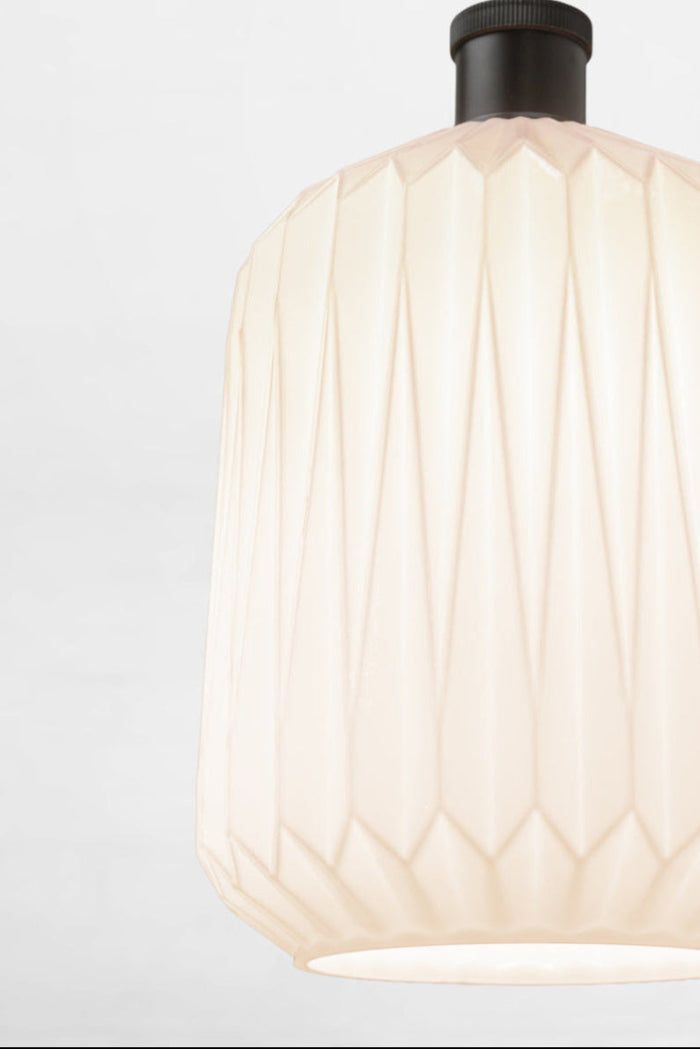 Close up of the opal shade with geometric design on a black lampholder.