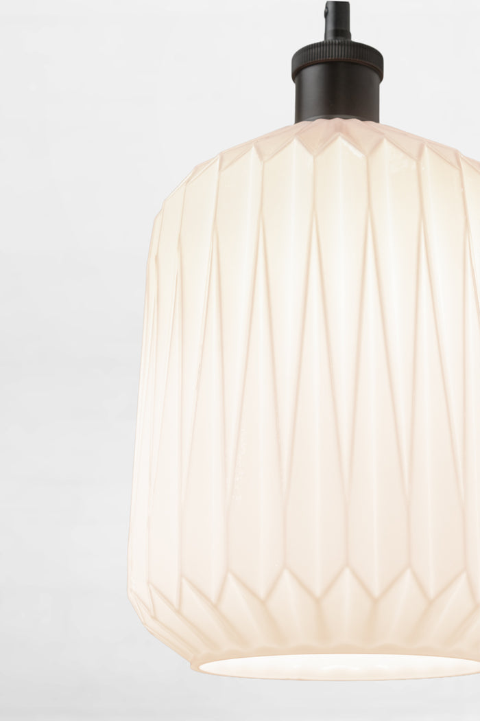 Close up of the opal shade with geometric design on a black lampholder.