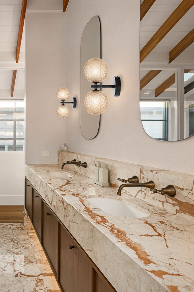Two black double up/down lampholder wall light with Amber tear finish, in a double sink bathroom.