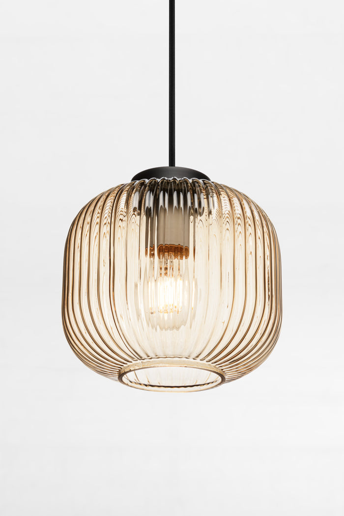 Reeded glass pendant in amber featuring vertical ridges across its surface