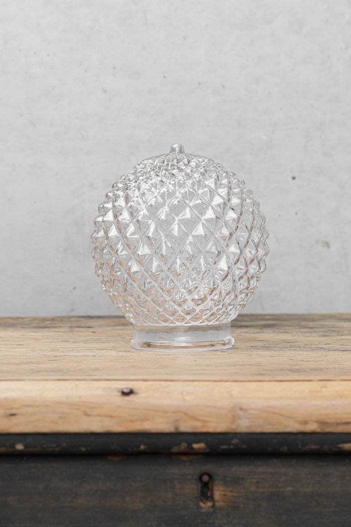 Uninstalled clear glass shade with a vintage textured design.