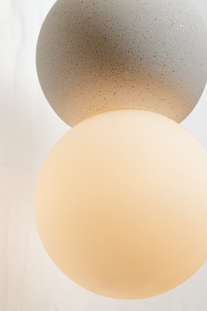 Close up of the glass and concrete orb pendant light on black cord