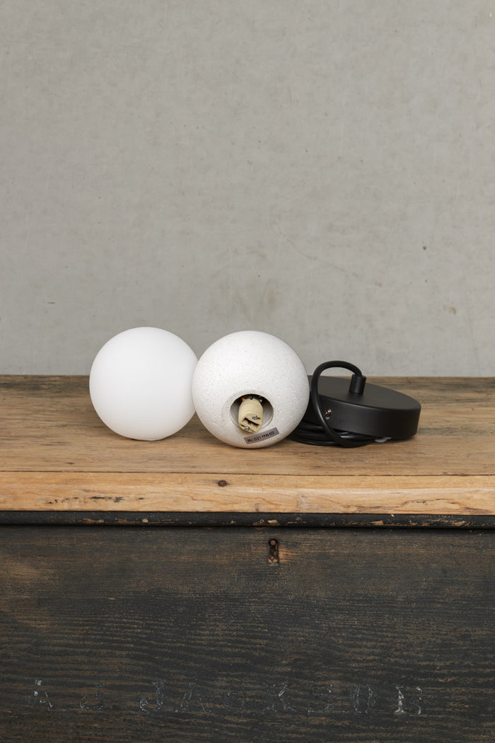 Uninstalled Glass and concrete orb pendant light on black cord