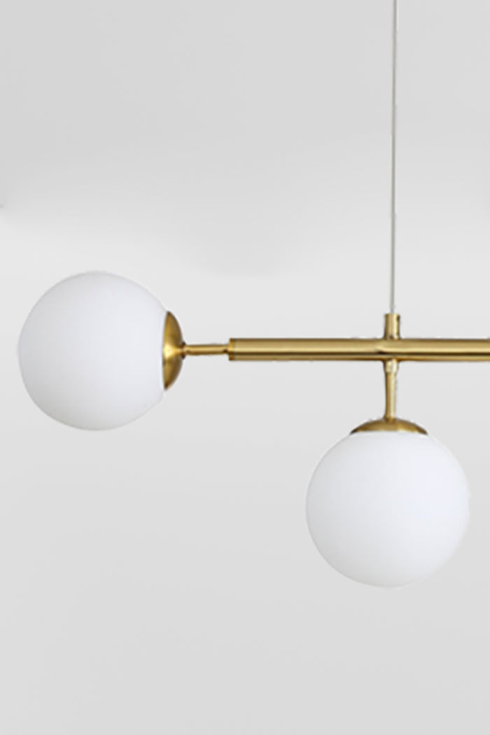 Close up of the gold/brass 6 light linear glass ball pendant light.