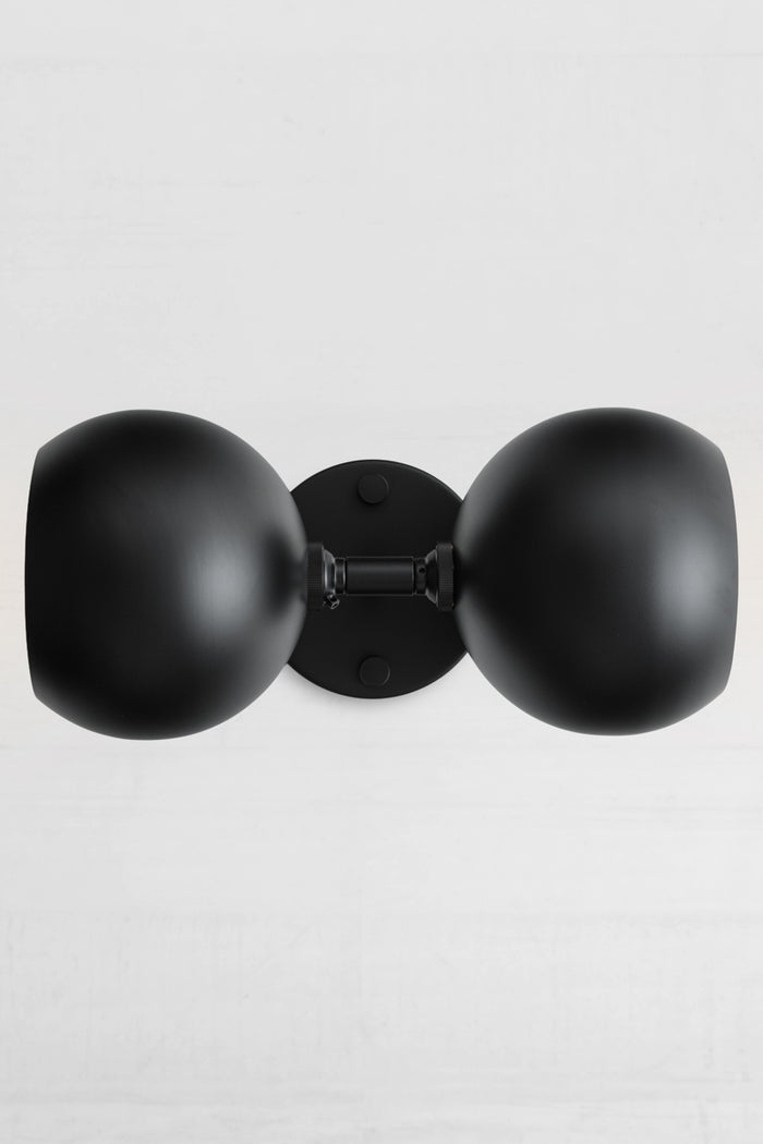 Sideways installation og the black double wall sconce with two steel bulb shades in black.