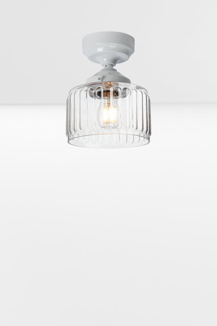 Clear glass shade with fluted detailing paired with a white batten holder and gallery.