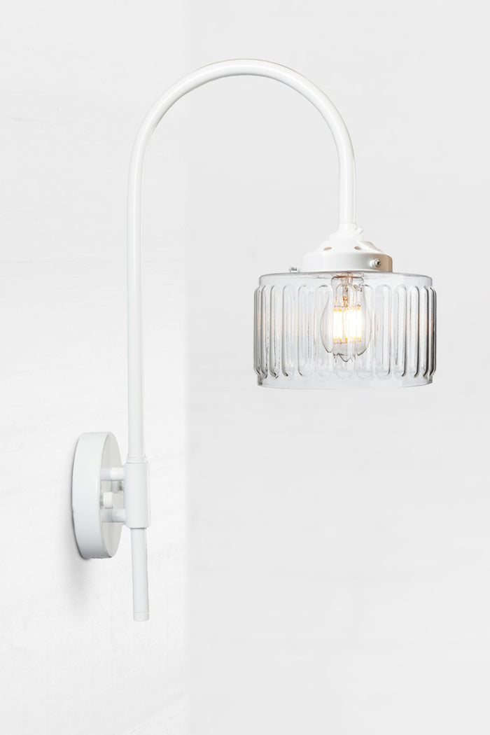 White shepherds hook wall light paired with a clear glass shade.