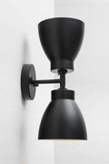 Black double wall sconce with two black metal shades.