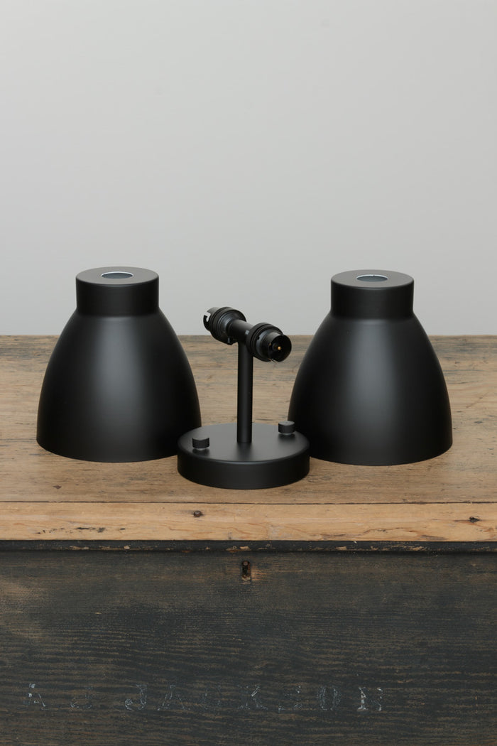 Uninstalled black double wall sconce with two black metal shades.