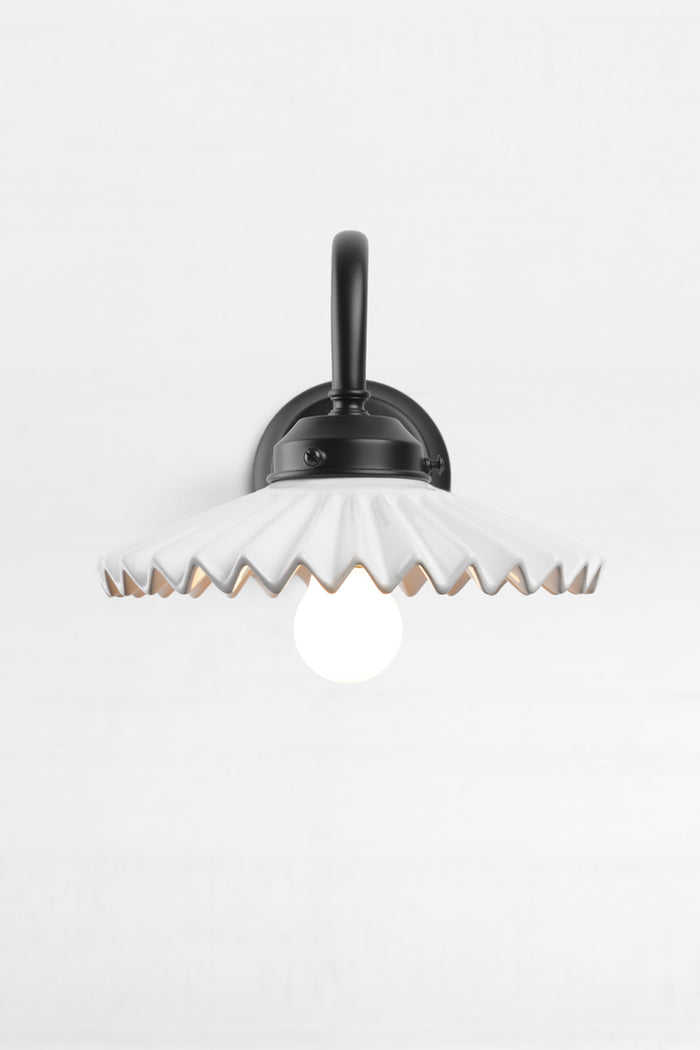 Front view of the black gooseneck wall arm with an integrated 2 and 1/4 cup, paired with a white ceramic shade.
