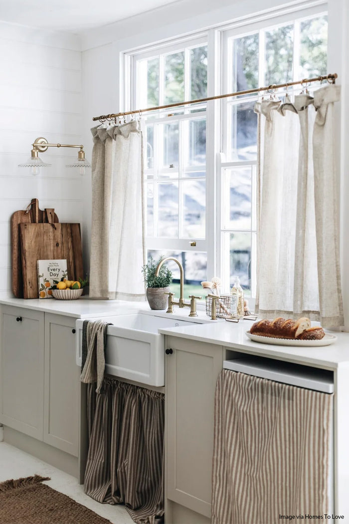 Double swivel arm wall sconce in gold/brass with two clear fril Charmont shades in a farmhouse style kitchen. Image Vis Homes to Love.