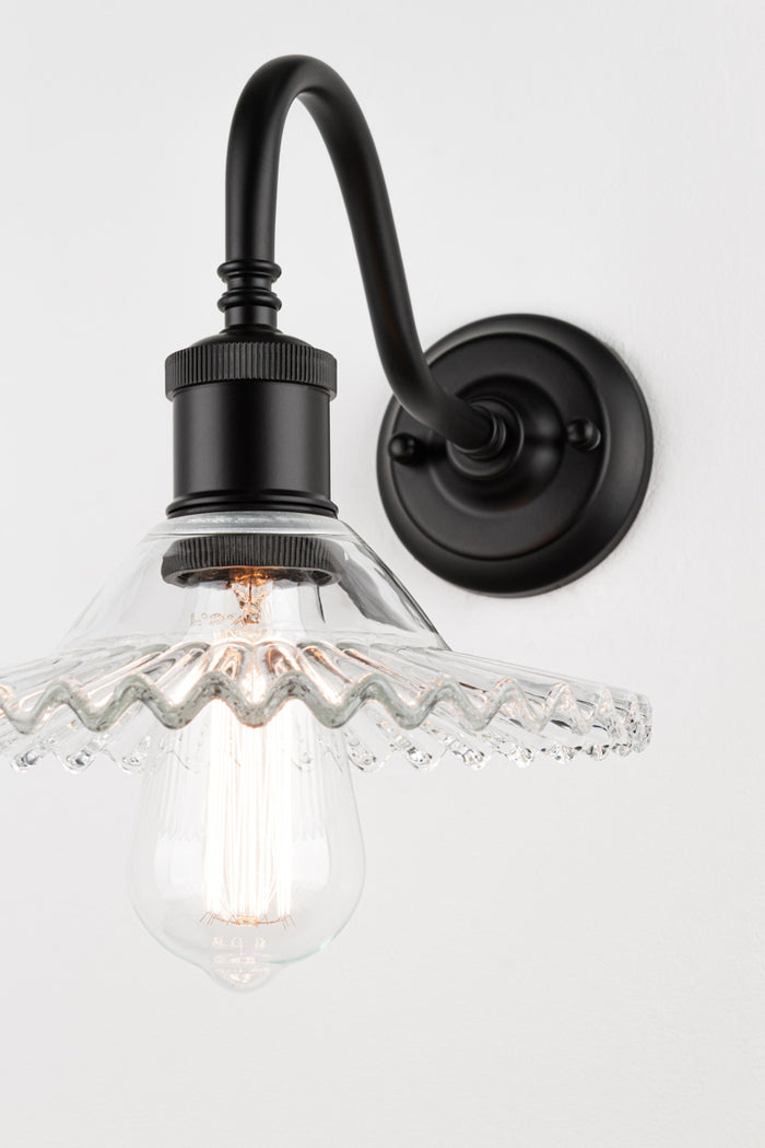 Close up of the Outdoor gooseneck wall sconce in black with clear glass frilled shade and teardrop bulb.