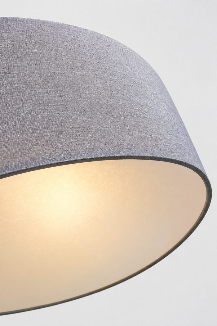 Close-up of the underneith of the grey fabric drum shade on the Clemente pendant light highlighting the woven fabric texture.