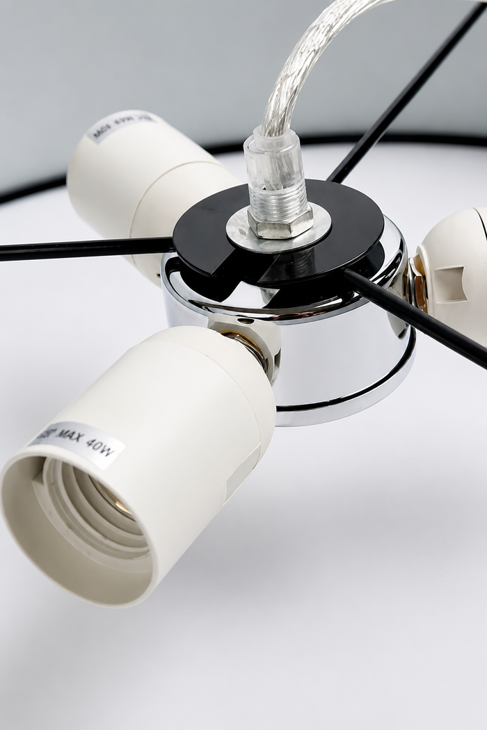 Close-up of the Clemente pendant light ceiling canopy with black fabric cord and white lampholder assembly.