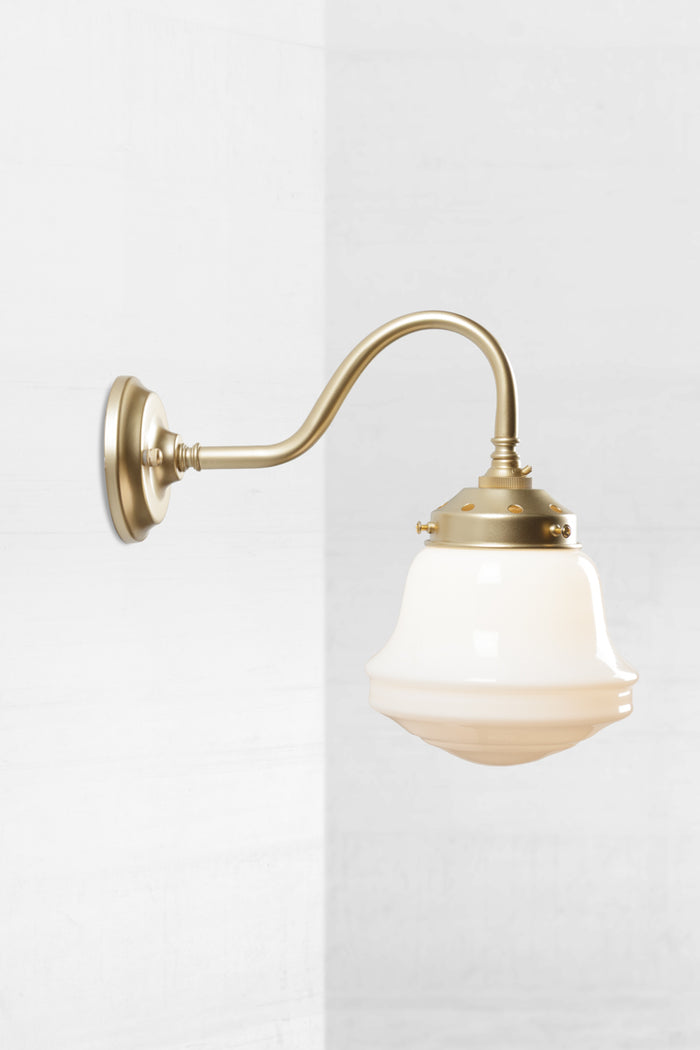 Gold/brass gooseneck wall sconce with an opal schoolhouse style shade.