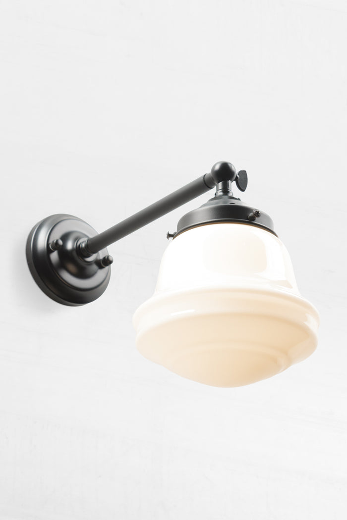 Opal schoolhouse style shade on a long, black, straight arm wall sconce.