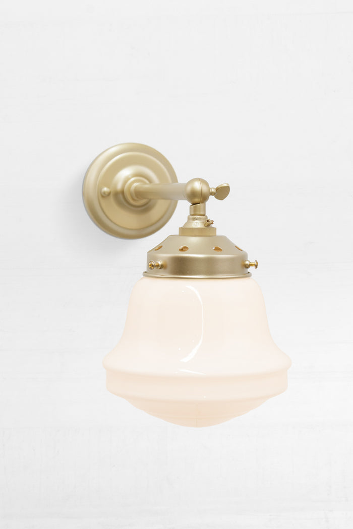 Opal schoolhouse style shade on a short, gold/brass, straight arm wall sconce.