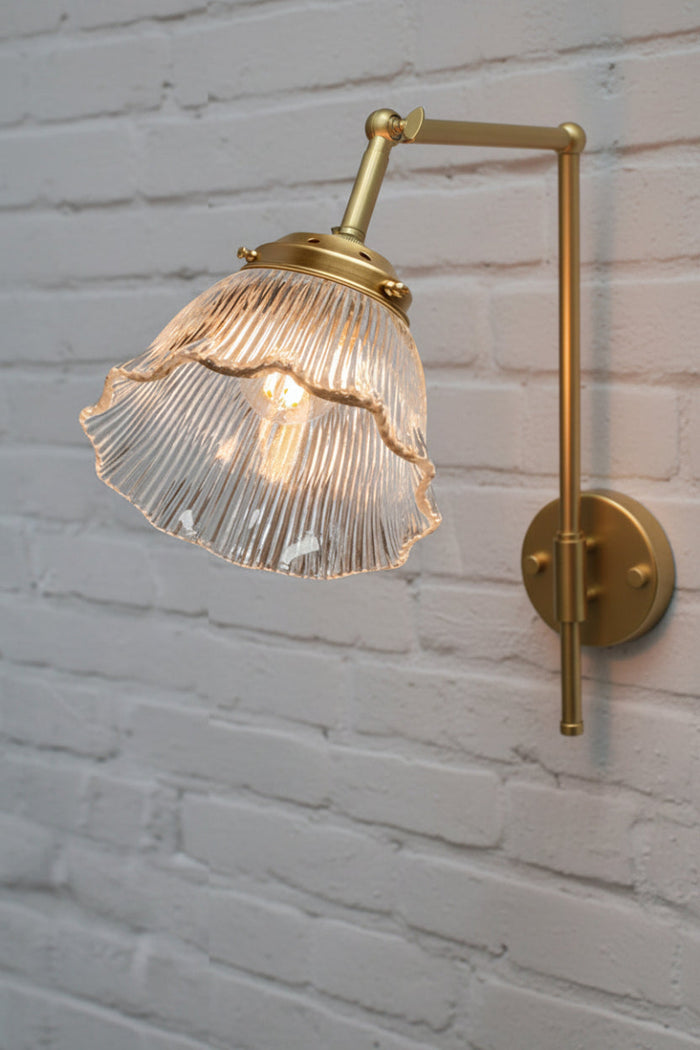 Gold/brass wall sconce with ribbed frill edged shade.