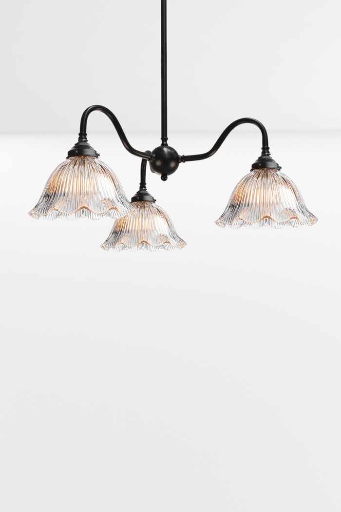Black 3 light gooseneck chandelier with frilledge clear glass ribbed shades.