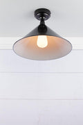 Large black cone shade on a black IP rated battenholder, underneith view.