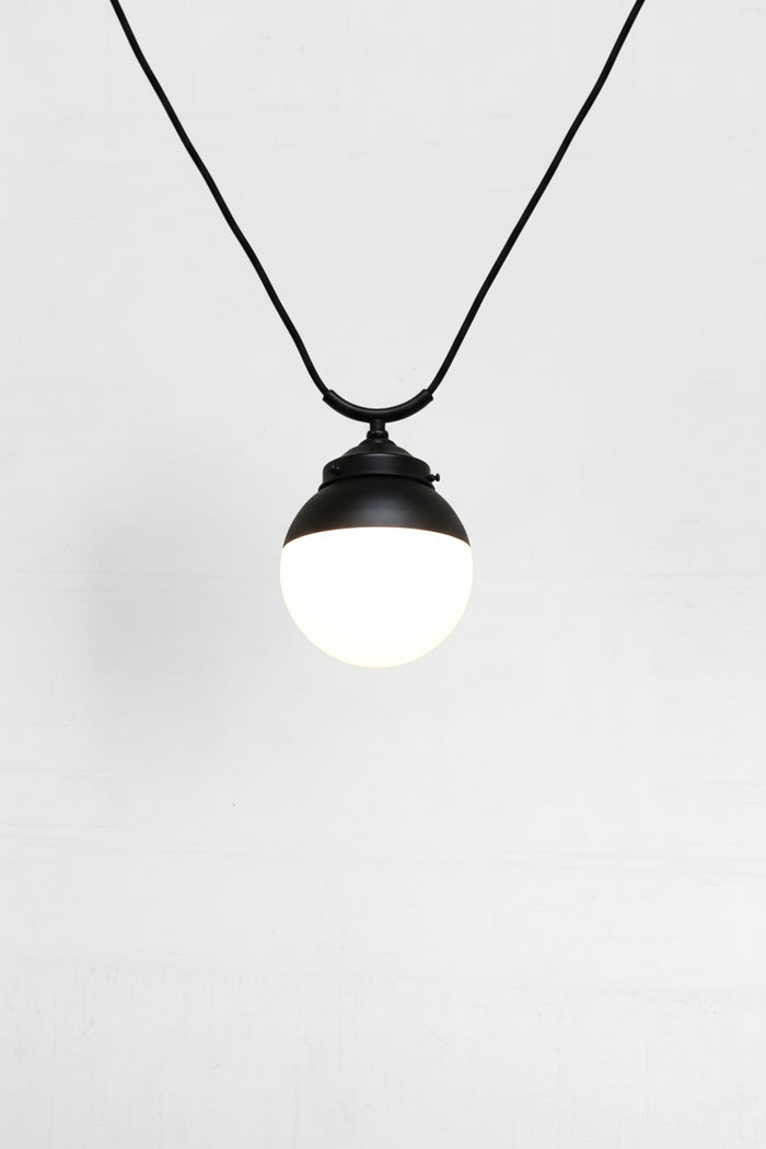glass ball shades shown on a black trapeze pendant cord.