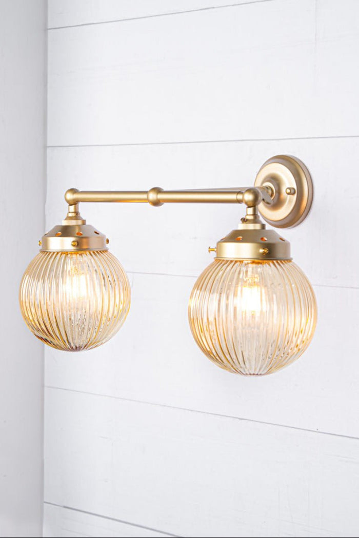 gold brass arm sconce with amber shades