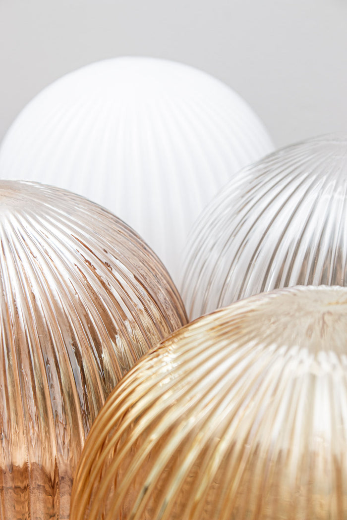 Close up of the reeded detailing on the glass ball shades in dark amber, opal, clear and amber finishes.