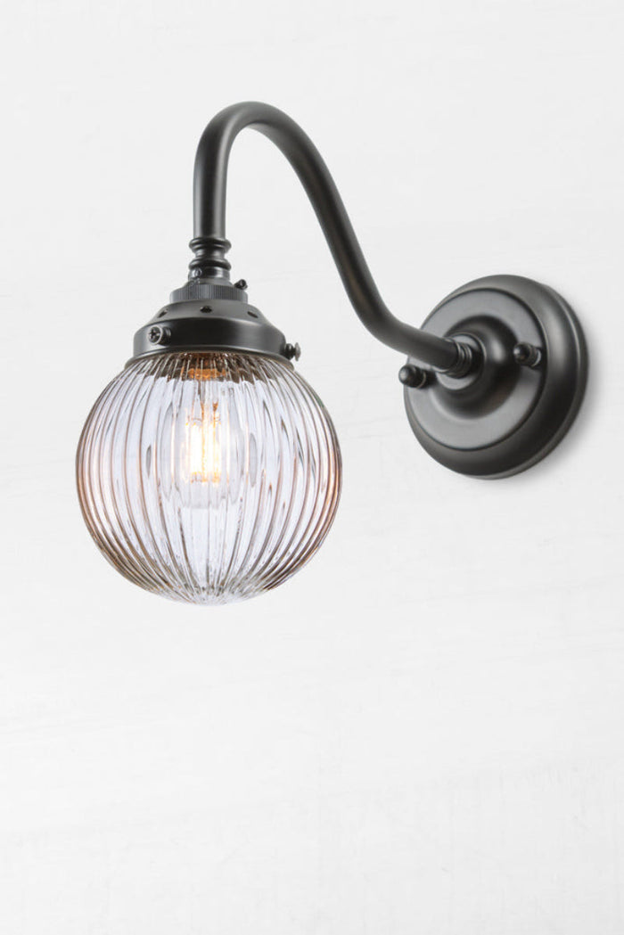 Black gooseneck wall sconce with a clear reeded glass ball shade.