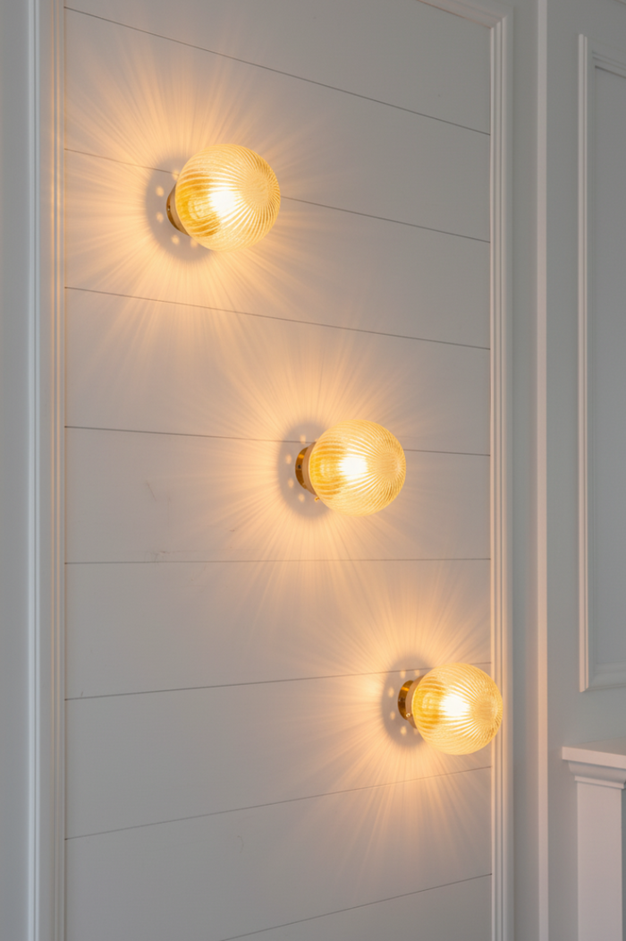 Three dakota reeded clear class wall lights at the top of a modern home staircase.