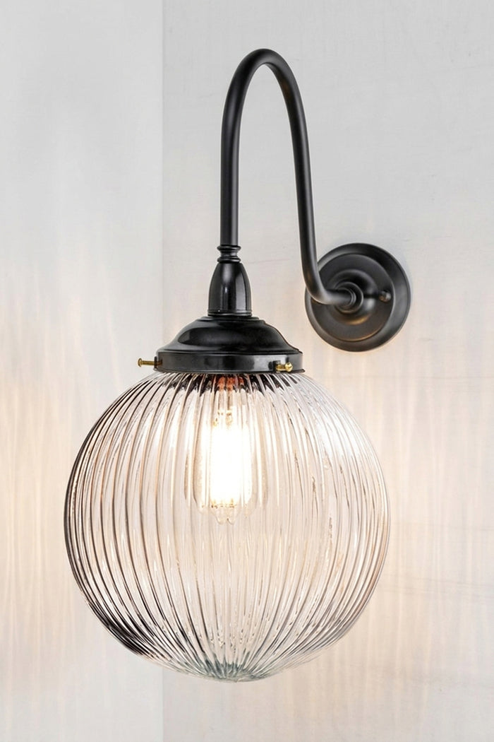 Medium clear reeded glass ball shade on an extra large gooseneck outdoor wall arm in black.
