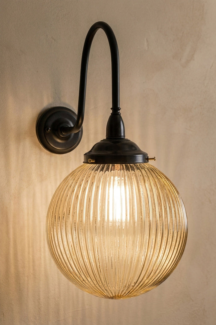 Medium amber reeded glass ball shade on an extra large gooseneck outdoor wall arm in black.