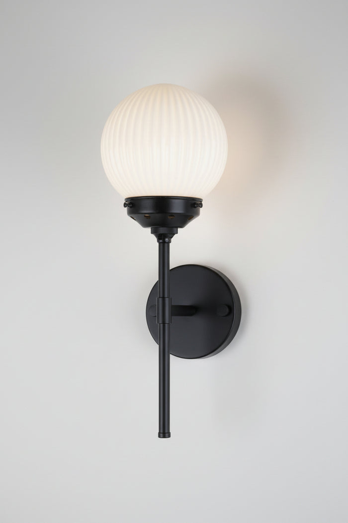 Opal glass ball shade with reeded detailong paired with a black stem wall sconce