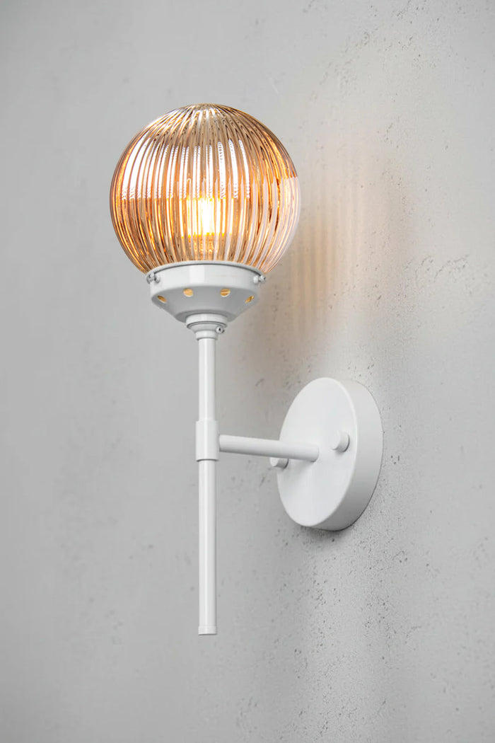 Reeded glass ball shade in dark amber with a white stem wall ssconce