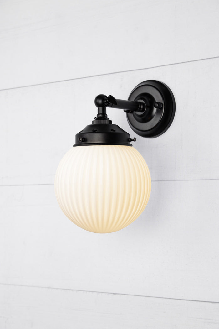 Opal glass reeded ball shade on a short black swivel straight arm.