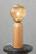 Dakota Wood Table Lamp with amber reeded glass shade illuminated