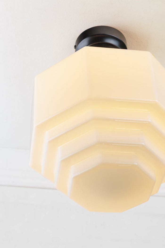 Close up of the opal glass teired shade on a black batten holder