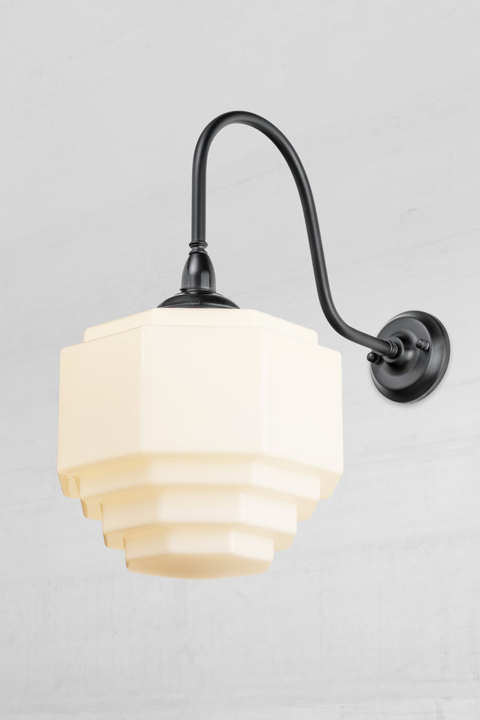 Stepped opal glass shade paired with an oversized black gooseneck wall arm with a bakelite gallery.