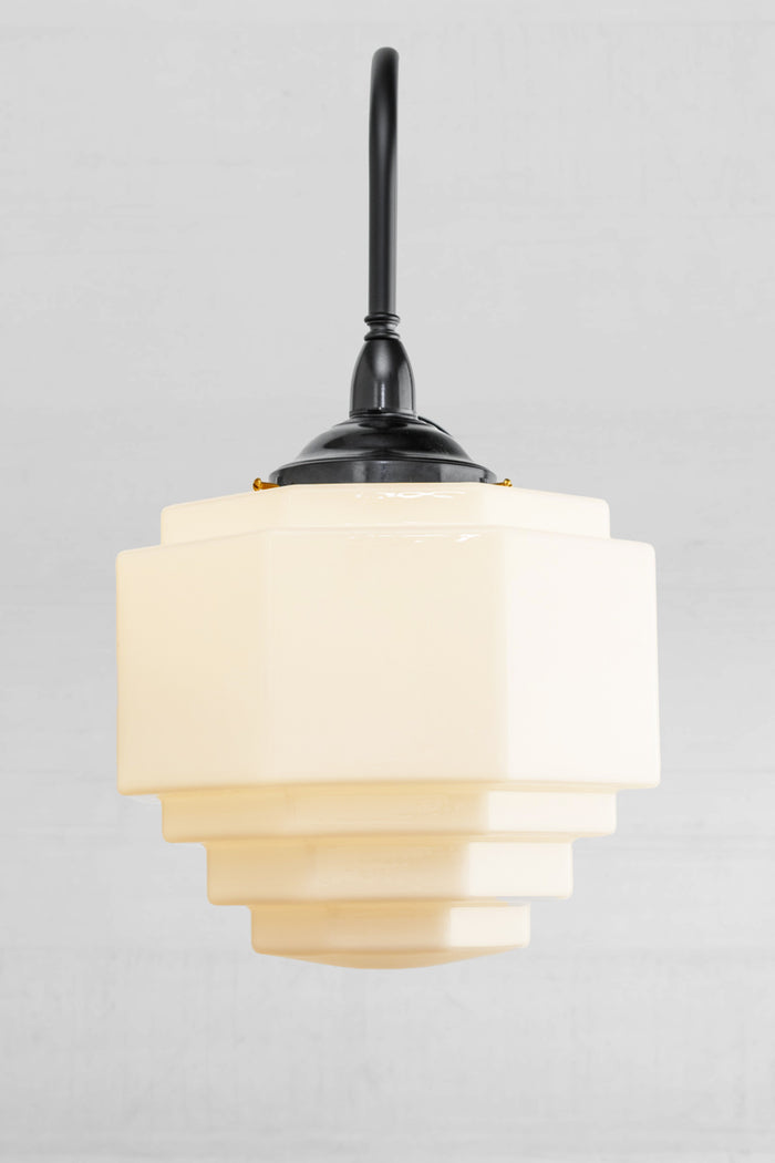 Front view of the large black gooseneck wall arm with a bakelite gallery and a stepped opal glas shade.