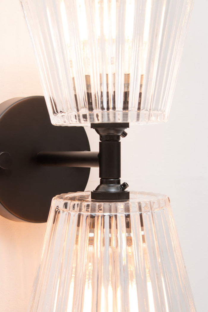 Close-up of Davis Glass Double Light Wall Sconce showing tapered vertically fluted clear glass shades